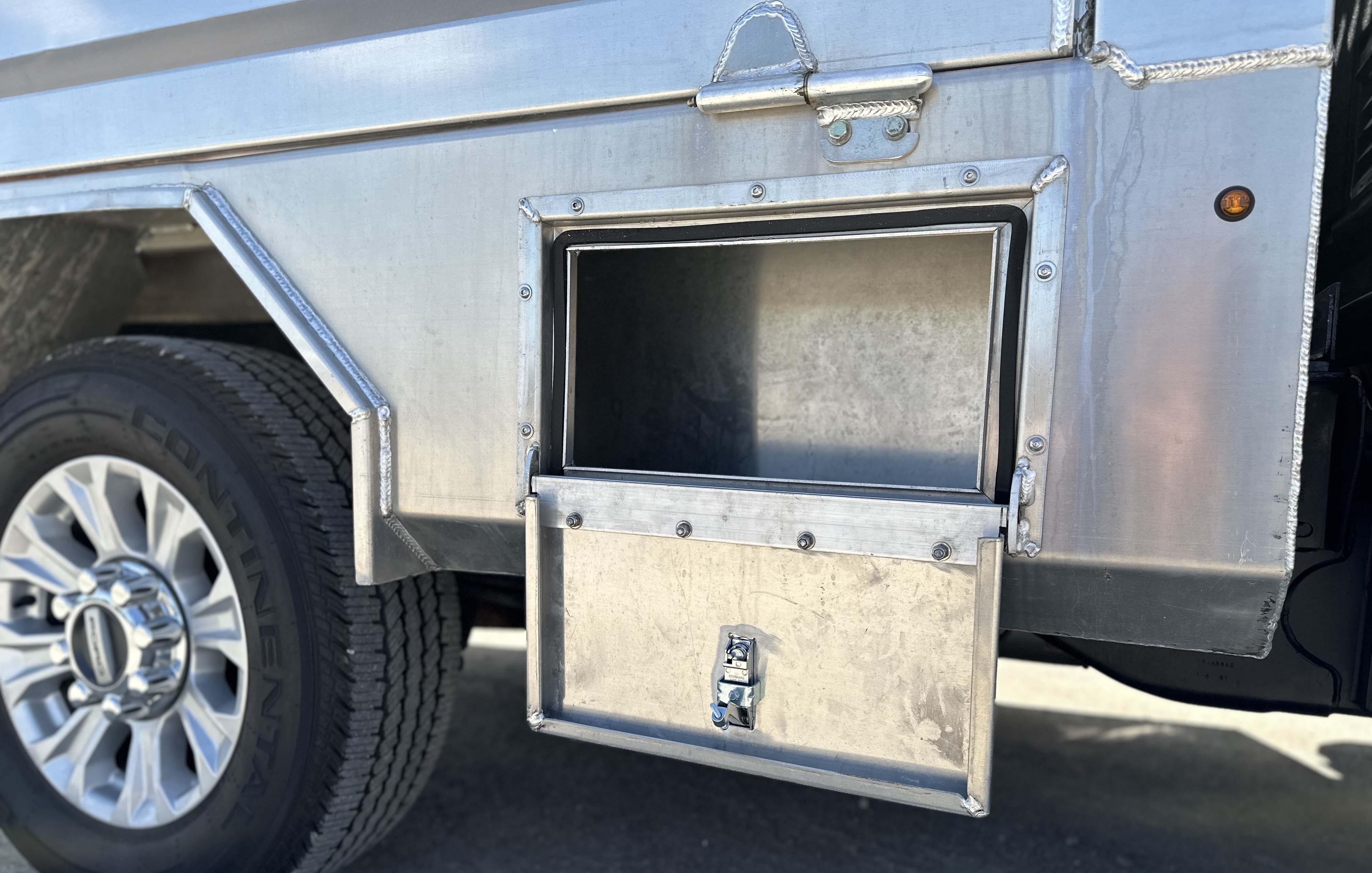 Curb side view of Voth Unibody Box Delete Truck - storage compartment open
